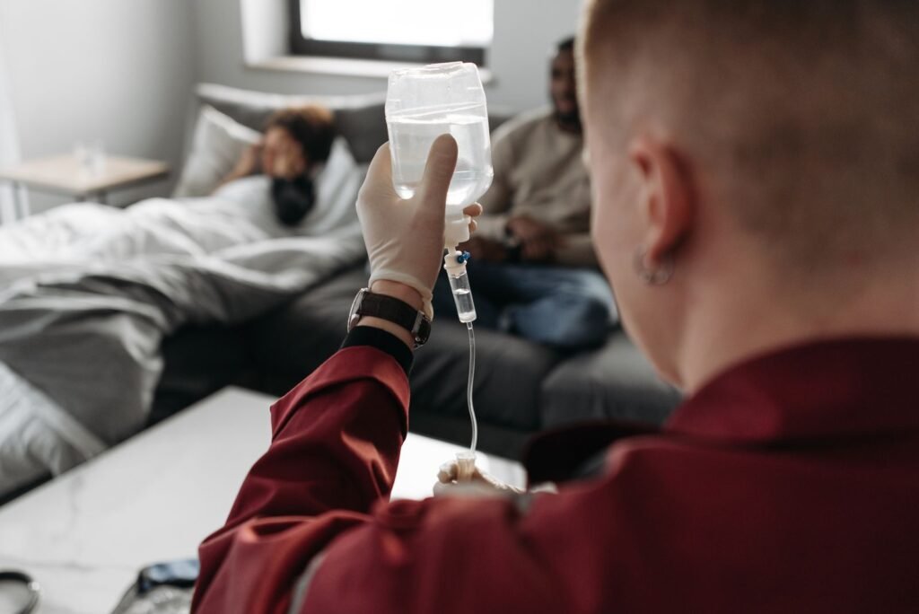 Tenaga medis memasang infus untuk pasien di rumah