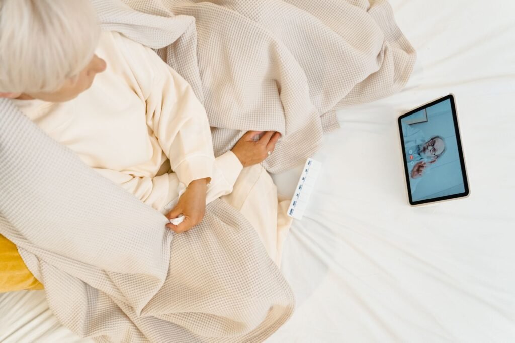 Pasien berkonsultasi dengan dokter menggunakan tablet dari tempat tidur